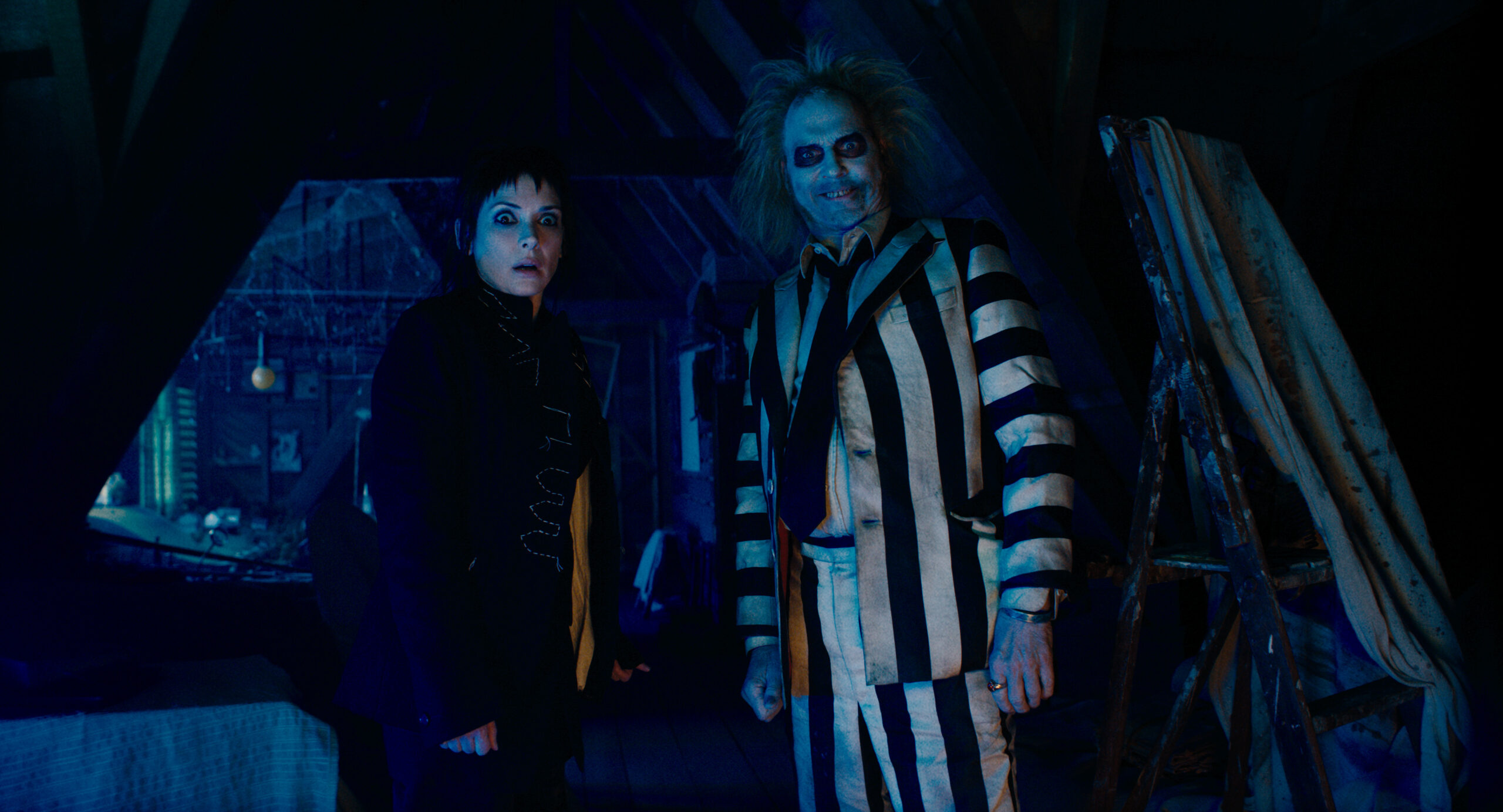 production still of a spooked Winona Ryder character standing next to creepy Beetlejuice.